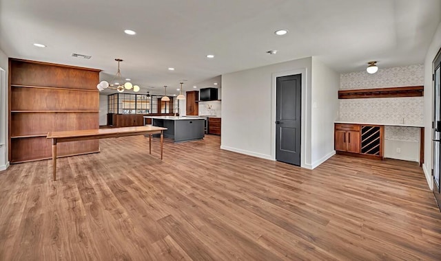 rec room with recessed lighting, baseboards, an inviting chandelier, and wood finished floors