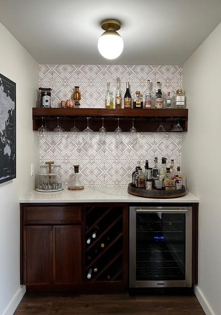 bar featuring dark wood-type flooring, backsplash, wine cooler, a bar, and baseboards