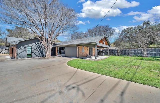 back of house with a patio, fence, a yard, concrete driveway, and brick siding