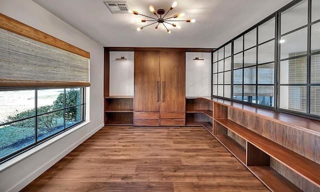 interior space featuring visible vents, wood finished floors, and a chandelier