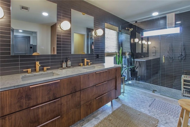 full bathroom with a shower stall, tile walls, visible vents, and a sink