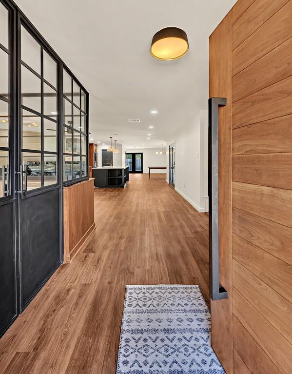 corridor featuring recessed lighting, wood finished floors, and visible vents