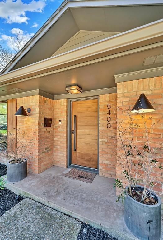 doorway to property with visible vents and brick siding