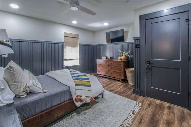 bedroom featuring recessed lighting, wood finished floors, a wainscoted wall, and ceiling fan