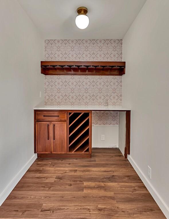 bar featuring baseboards and wood finished floors