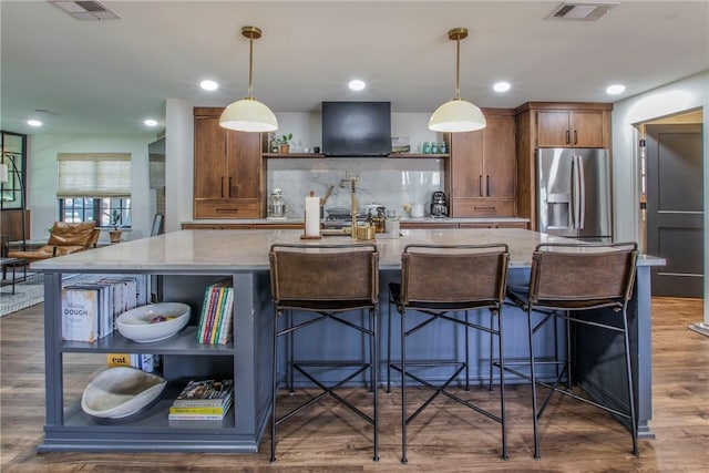 kitchen with open shelves, wood finished floors, stainless steel fridge with ice dispenser, and visible vents