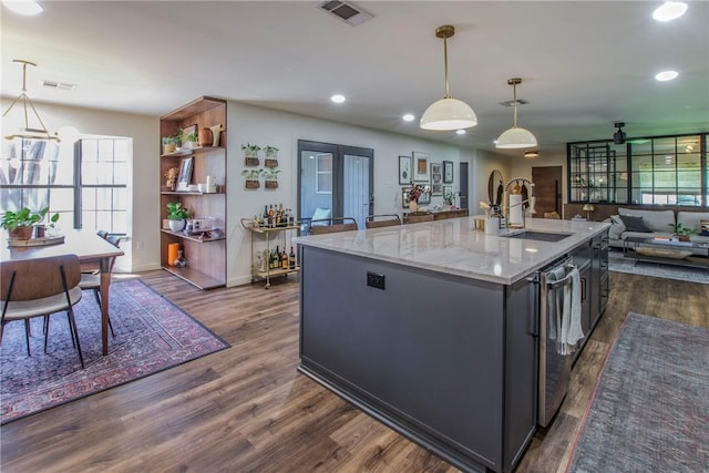 kitchen with visible vents, an island with sink, a sink, dark wood-type flooring, and open floor plan