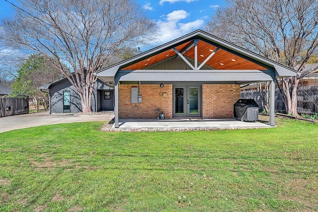 back of house with a patio, fence, french doors, a lawn, and brick siding