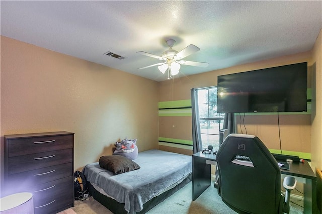 carpeted bedroom with a textured ceiling and ceiling fan