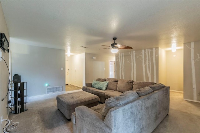 carpeted living room with a textured ceiling and ceiling fan