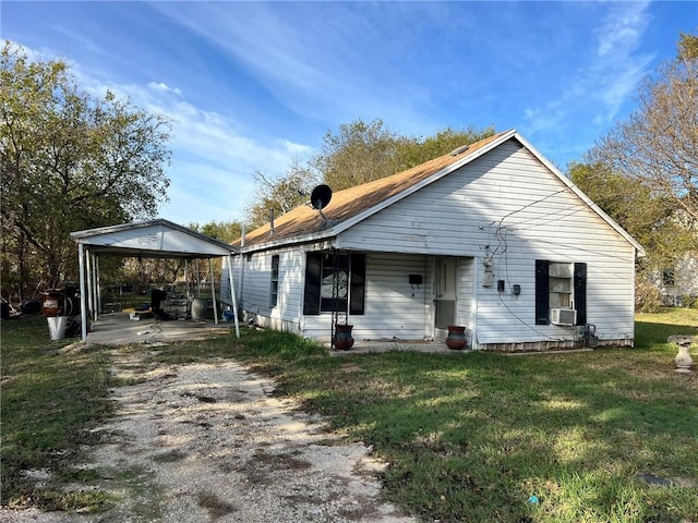 view of front of home featuring cooling unit, a front yard, and a carport