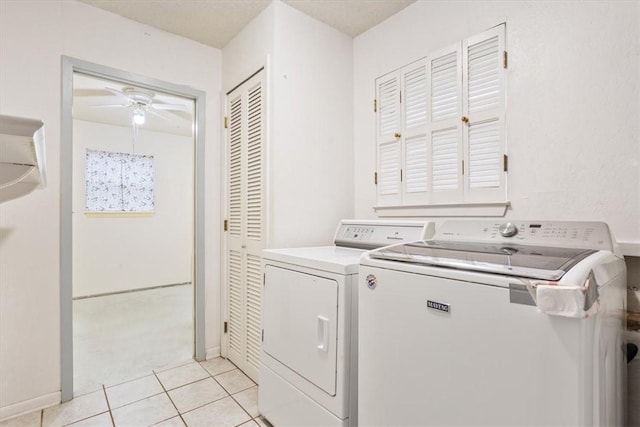 clothes washing area featuring ceiling fan, light tile patterned floors, and washing machine and clothes dryer