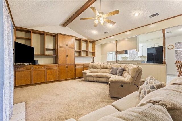 carpeted living room featuring vaulted ceiling with beams, a textured ceiling, and ceiling fan