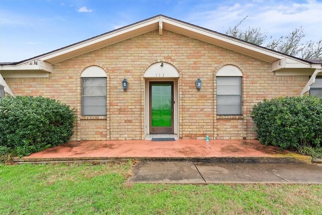 view of front of property featuring a front yard and a patio area