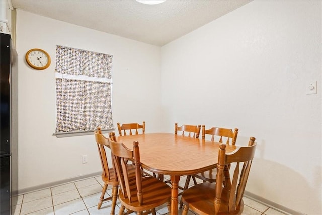 tiled dining area with a textured ceiling