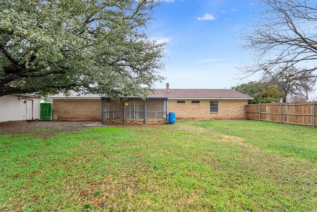 rear view of house featuring a lawn and a sunroom