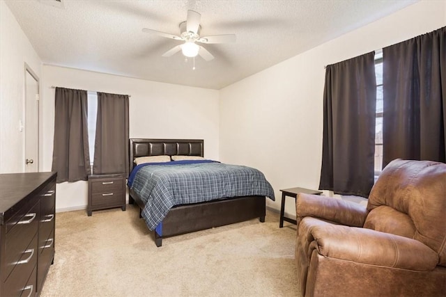 carpeted bedroom with ceiling fan and a textured ceiling