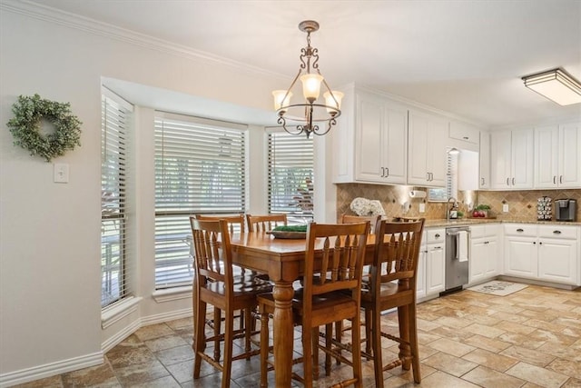 dining room with a notable chandelier, a healthy amount of sunlight, and ornamental molding