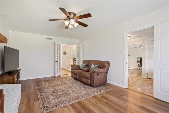 living room with hardwood / wood-style floors, ceiling fan, ornamental molding, and french doors