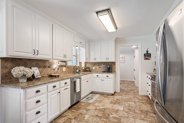 kitchen featuring white cabinets, appliances with stainless steel finishes, tasteful backsplash, and sink