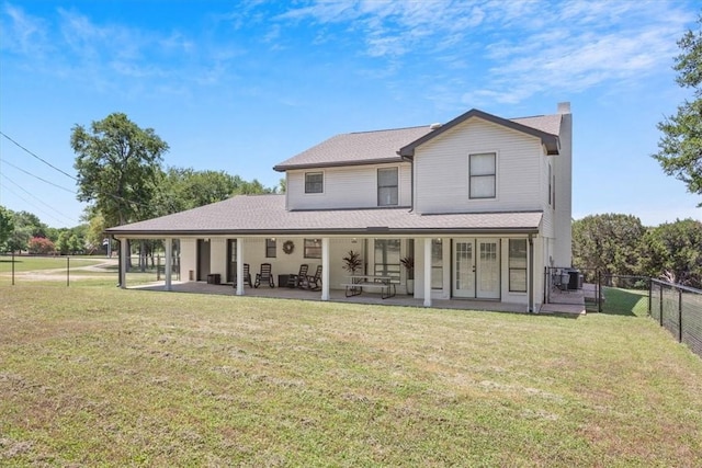 rear view of house with a yard and a patio