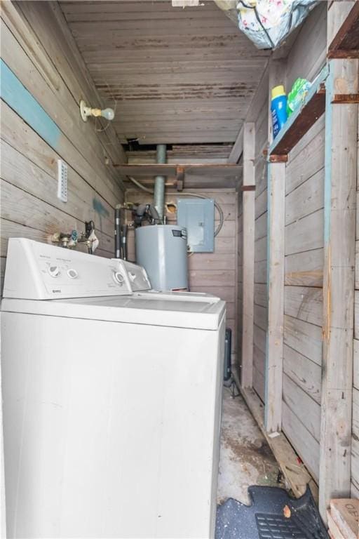 laundry room featuring wood walls, washer / dryer, electric panel, and water heater