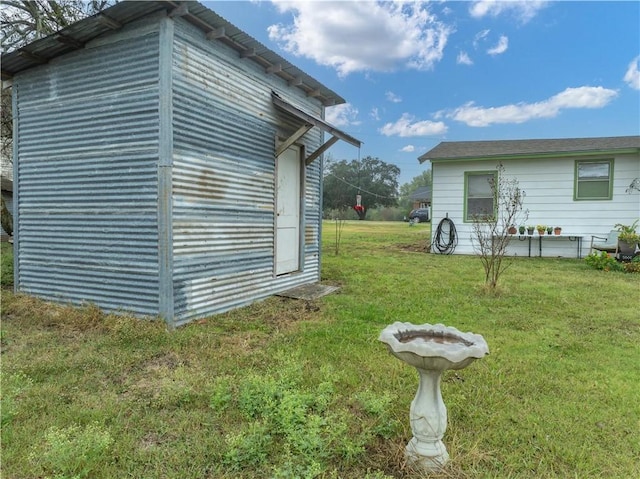 view of home's exterior with a yard and a storage unit