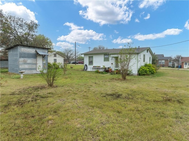 rear view of property featuring a lawn