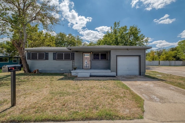 ranch-style house with covered porch, a garage, and a front lawn