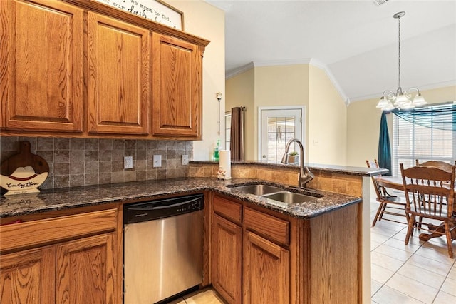 kitchen featuring dishwasher, sink, dark stone counters, and a chandelier