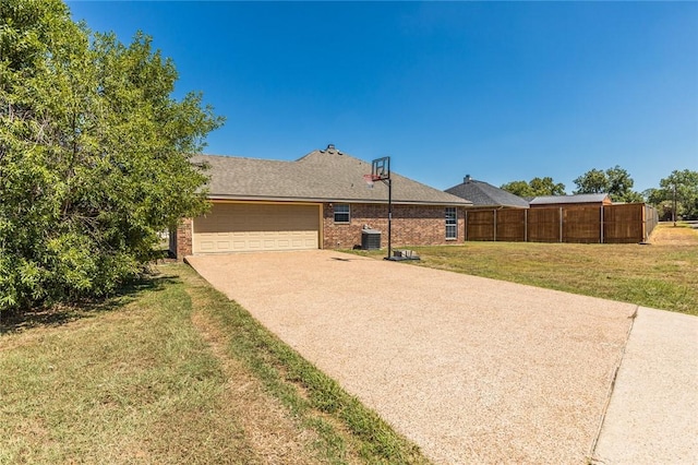 ranch-style house featuring a front yard, central AC, and a garage