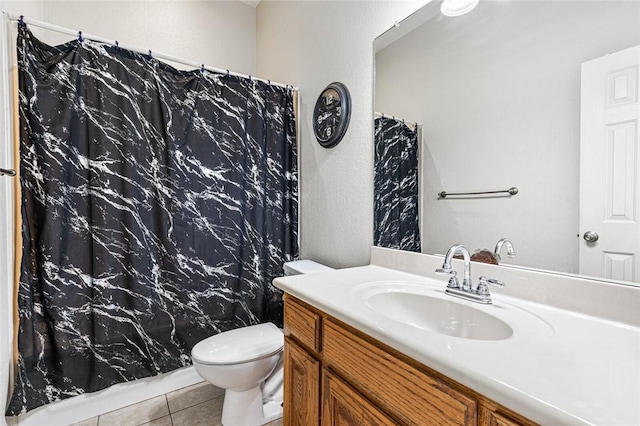 bathroom featuring tile patterned flooring, vanity, and toilet