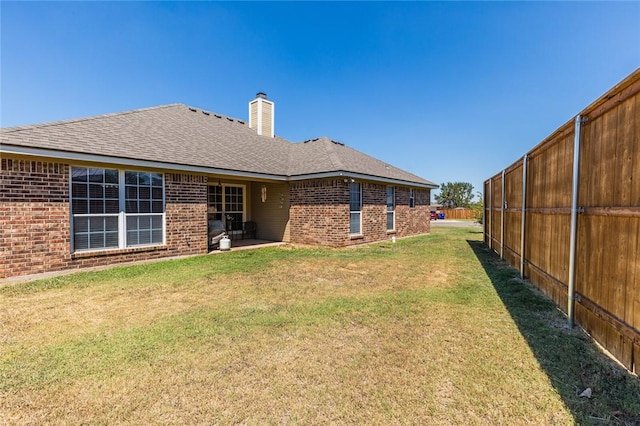 rear view of property featuring a patio and a lawn