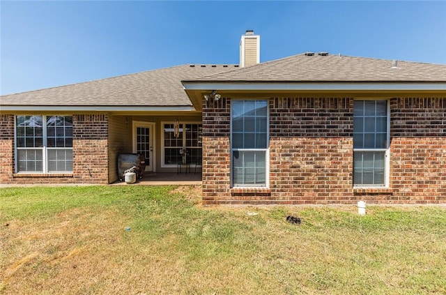 rear view of house with a lawn and a patio area