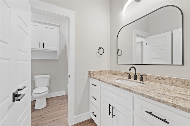 bathroom featuring toilet, vanity, and hardwood / wood-style flooring