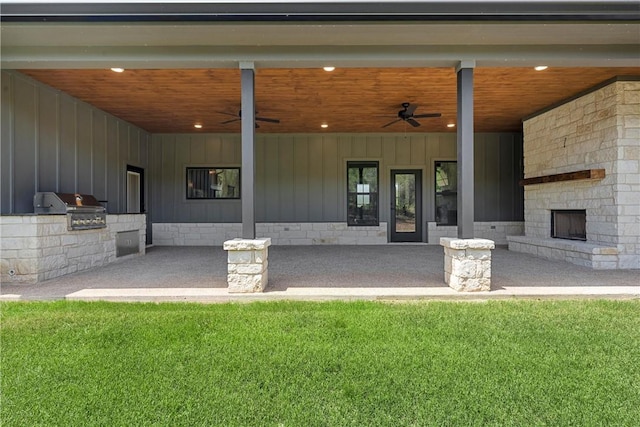 exterior space featuring a lawn, a patio area, ceiling fan, and an outdoor kitchen