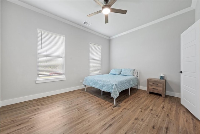 bedroom featuring ceiling fan, light hardwood / wood-style floors, and crown molding