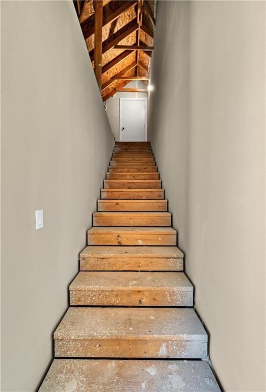 stairs featuring vaulted ceiling with beams