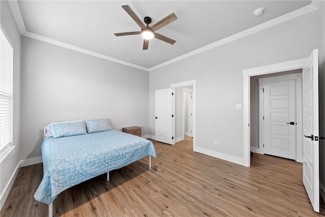 bedroom featuring ceiling fan, wood-type flooring, and ornamental molding