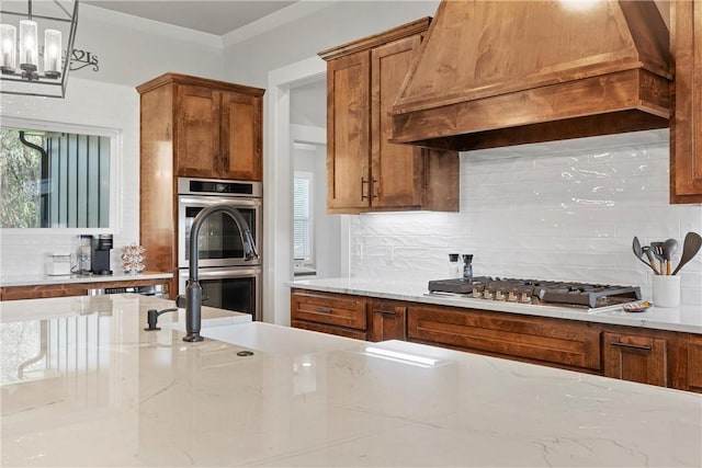 kitchen featuring backsplash, light stone counters, custom range hood, and stainless steel appliances