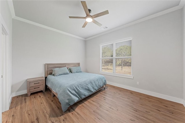 bedroom with light hardwood / wood-style flooring, ceiling fan, and ornamental molding