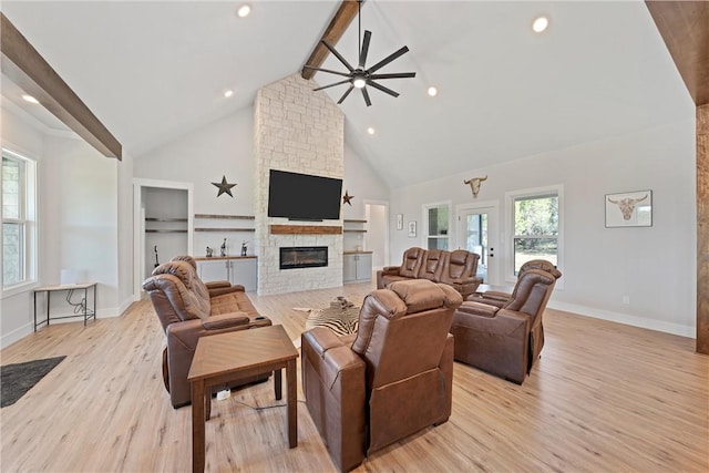 living room featuring ceiling fan, beam ceiling, high vaulted ceiling, a fireplace, and light hardwood / wood-style floors