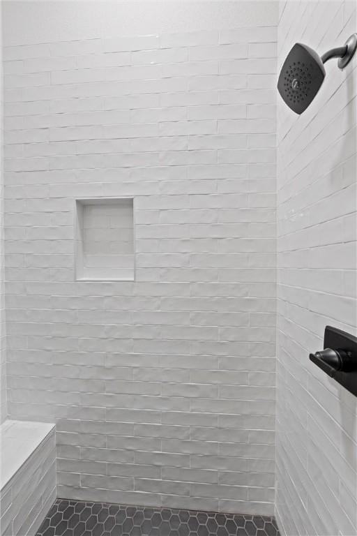 bathroom featuring tile patterned flooring and a tile shower