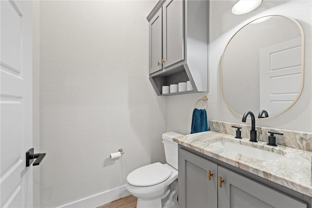 bathroom featuring hardwood / wood-style floors, vanity, and toilet