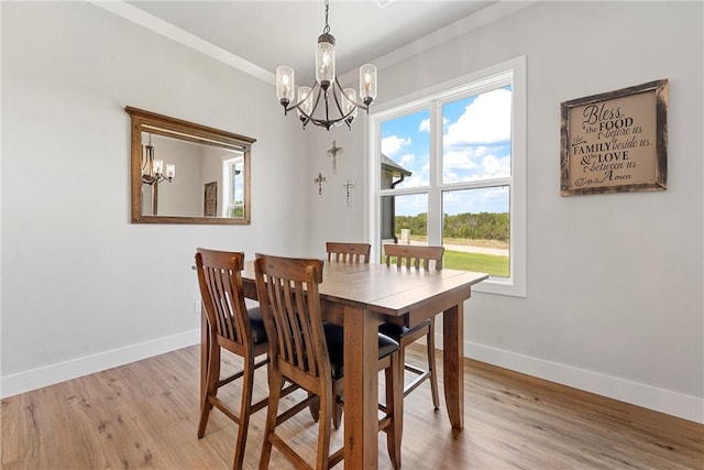 dining space featuring light wood-type flooring and an inviting chandelier