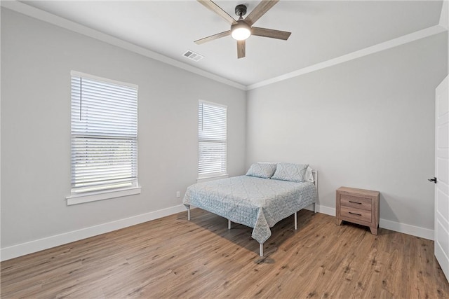 bedroom featuring ceiling fan, crown molding, and light wood-type flooring