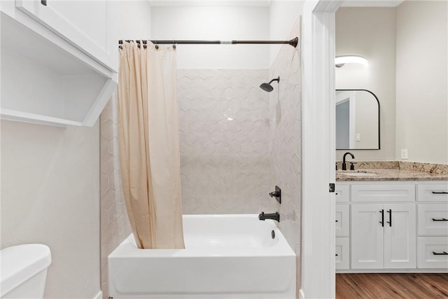 full bathroom featuring hardwood / wood-style flooring, shower / bath combo, toilet, and vanity