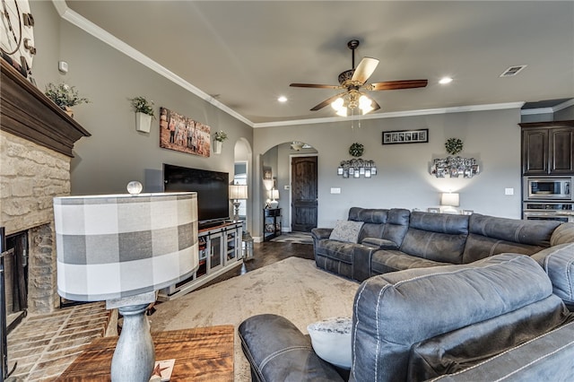 living room with a fireplace, ceiling fan, and crown molding