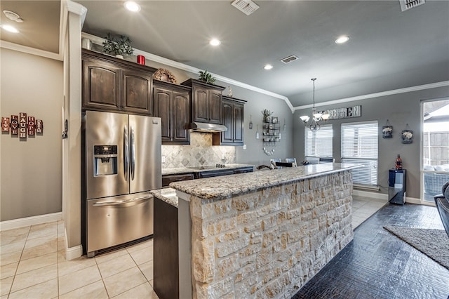 kitchen featuring stainless steel fridge with ice dispenser, decorative backsplash, ornamental molding, an island with sink, and dark brown cabinetry