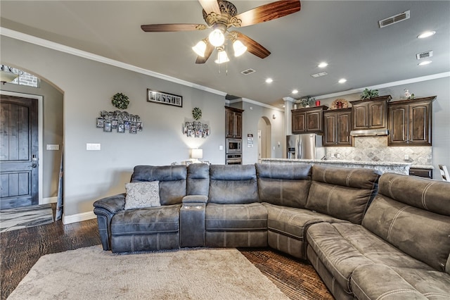 living room with crown molding, dark hardwood / wood-style flooring, and ceiling fan